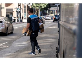 A worker delivers Amazon packages in San Francisco, California, US, on Wednesday, Oct. 5, 2022. Amazon.com Inc. will hold a second Prime Day sale on Oct. 11 and Oct. 12 to boost sales among cost-conscious consumers who are expected to start their holiday shopping even earlier this year.