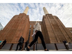 Pedestrians pass the Battersea Power Station development before the opening ceremony in London, UK, on Friday, Oct. 14, 2022. London's famous Battersea Power Station opened its doors for the first time in almost 40 years, taking on a new lease of life following a glitzy but sometimes controversial renovation.