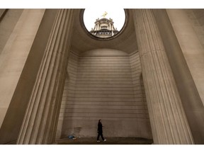 A commuter passes through arches of the Bank of England (BOE) in the City of London, UK, on Monday, Oct. 17, 2022. The Bank of England said it was restarting its corporate bond-selling as it looks to return to normality in the wake of a sustained selloff in UK assets.
