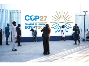Des participants prennent des photos devant une bannière lors de la conférence sur le climat COP27 à Sharm El-Sheikh, en Égypte.