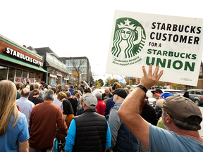 People gather outside a Starbucks location while singer Billy Bragg performs for striking Starbucks Workers United Union members in Buffalo, N.Y., in October.