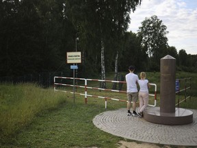 FILE - People visit the area of the place where borders of Poland, Lithuania and Russia's Kaliningrad Oblast meet, in Zerdziny, Poland, on July 7, 2022. Poland's defense minister says he has ordered the construction of a temporary barrier along the border with the Russian exclave of Kaliningrad. The decision comes as Warsaw suspects that Russia plans to facilitate the illegal border crossing by Asian and African migrants at the border.