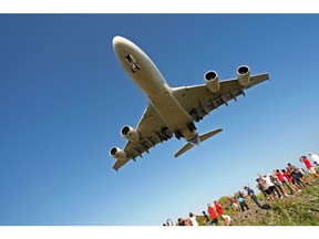 A file photograph shows people watching as an Airbus A380 flies over the Indian ocean island of La Réunion during an exhibition flight before landing at the Roland-Garros airport, near the city of Saint-Denis-de-la-Réunion, in 2009.