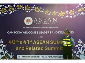 A security officer stands next to a billboard for the 40th and 41st ASEAN Summits in Phnom Penh on November 10, 2022.  Photographer: Nhac Nguyen/AFP/Getty Images