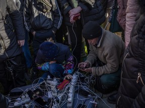 Residents gather next to an internet hotspot in Kherson, southern Ukraine, Monday, Nov. 14, 2022. The retaking of Kherson was one of Ukraine's biggest successes in the nearly nine months since Moscow's invasion.