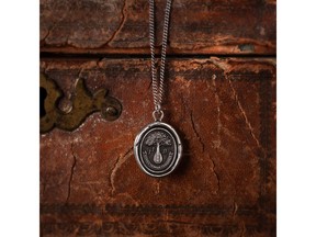 This talisman reads 'Musica Terram Coniungit' in Latin, meaning 'Music Unites the Earth.' The stringed instrument branching out into a tree is symbolic of the powerful connection between music and all living things. Pyrrha will donate full proceeds from the purchase of this talisman to support Pathway to Paris.