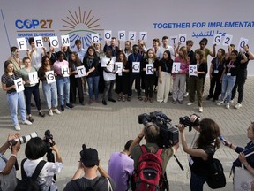 Youth climate activists hold signs that read "from COP27 to G20 fight for 1.5" at the COP27 U.N. Climate Summit, Monday, Nov. 14, 2022, in Sharm el-Sheikh, Egypt.
