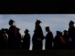 Graduates are silhouetted as they line up for a convocation ceremony at Simon Fraser University, in Burnaby, B.C., on Friday, May 6, 2022.