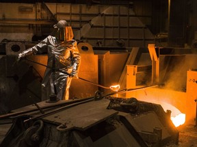 FILE -- An employee in protective clothing takes a sample from the furnace at the steel producer, Salzgitter AG, in Salzgitter, Germany, Thursday, March 22, 2018. Germany's biggest industrial union has agreed with employers on a pay deal that will see millions of workers get raises totaling 8.5% over two years as well as one-time payments meant to cushion the effect of sky-high inflation.