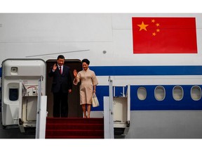 Chinese President Xi Jinping and his wife Peng Liyuan wave as they arrive at Ngurah Rai International airport in Bali on November 14. Photographer: Ajeng Dinar Ulfiana/AFP/Getty Images