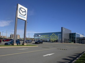 A Mazda car dealership with a partially filled lot is seen in Dartmouth, N.S., Monday, Oct. 31, 2022. Because of supply issues, many vehicles are sold before they hit the lot, leaving some dealership parking lots nearly empty while waiting lists grow longer.