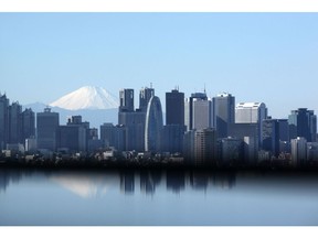 Mount Fuji stands behind buildings in Tokyo. Photographer: Tomohiro Ohsumi