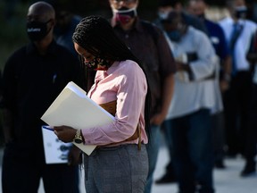 People wait in line to attend a job fair in California.
