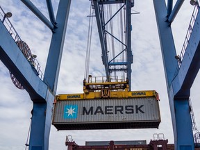 A gantry crane moves a AP Moeller-Maersk A/S shipping container at a port in India.