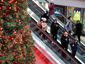 Shoppers pass by the Christmas tree at Eaton Centre mall in downtown Toronto.