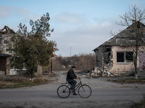 A local resident rides a bike near destroyed houses, amid Russia's attack on Ukraine, in the village of Arkhanhelske, Kherson region, Ukraine.