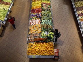 Shoppers browse produce at a Loblaw Companies Ltd. grocery store in Toronto.