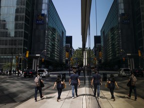 Pedestrians walk near a Royal Bank of Canada building in the financial district of Toronto.