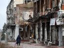 A local resident walks past heavily damaged buildings in the town of Izyum, Kharkiv region, amid the Russian invasion of Ukraine. 