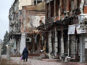 A local resident walks past heavily damaged buildings in the town of Izyum, Kharkiv region, amid the Russian invasion of Ukraine.