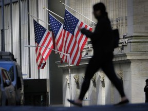 FILE - A pedestrian walks past the New York Stock Exchange in New York City, Thursday, Oct. 27, 2022.