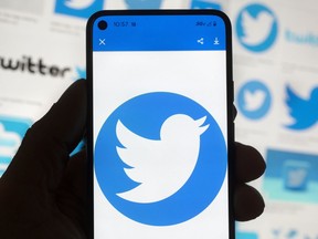 The Twitter logo is seen on a cell phone, Friday, Oct. 14, 2022, in Boston. While amount of chaos is expected after a corporate takeover, as are layoffs and firings, Elon Musk's murky plans for Twitter -- especially its content moderation, misinformation and hate speech policies -- are raising alarms about where one of the world's most high-profile information ecosystems is headed.