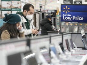 FILE - Signs advertise deals and low prices at a Walmart in Secaucus, N.J., Tuesday, Nov. 22, 2022. On Tuesday the Conference Board reports on U.S. consumer confidence for November.