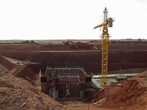 In this Nov. 7, 2009, file photo, a crane hovers above the site of a new shaft under construction at the Oyu Tolgoi mine site in Khanbogd village, Umnugobi province, Mongolia.