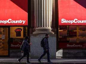 Sleep Country Canada Holdings Inc. says its net income for the third quarter went down by almost 21 per cent to $28.9 million, from $36.5 million during the same quarter a year earlier. Pedestrians walk past a Sleep Country Canada store on Yonge Street in Toronto on October 19, 2021.