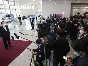 South Korean President Yoon Suk Yeol, left, answers reporters' questions upon his arrival at the presidential office in Seoul, South Korea, Friday, Nov. 18, 2022. South Korea's new president has suspended his routine morning Q&A sessions with journalists -- an unprecedented practice in the country's politics that drew both praises and worries -- after he was embroiled in a squabbling with a local broadcaster over its coverage of his remarks caught on a hot mic in the United States.