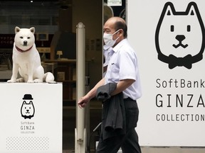 FILE - A man walks in front of a SoftBank shop in Tokyo on July 29, 2021. Japanese technology investor SoftBank Group Corp. reported on Friday, Nov. 11, 2022, a 3 trillion yen ($21 billion) profit for the July-September quarter, a turnaround from a loss a year earlier.
