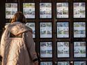 A person walks past real estate ads in Toronto.