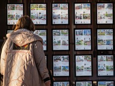 A person walks past real estate postings in Toronto.