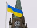 The Ukrainian flag flies in front of the Peace Tower on Parliament Hill after Ukraine's President Volodymyr Zelenskiy addressed Canada's parliament this past March. Canada will issue a Ukraine Sovereignty Bond to provide aid for the nation in November. 
