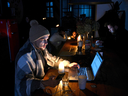 People take refuge in a coffee shop in Lviv as the city endures a scheduled power outage on Nov. 24, following the latest Russian airstrikes on Ukraine's energy infrastructure.