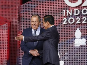 Russian Foreign Minister Sergey Lavrov greets Indonesia's President Joko Widodo as he arrives for the G20 leaders' summit in Nusa Dua, Indonesia, Tuesday, Nov. 15, 2022.