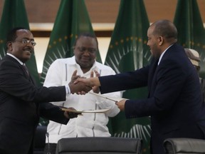 Lead negotiator for Ethiopia's government, Redwan Hussein, left, shakes hands with lead Tigray negotiator Getachew Reda, as Kenya's former president, Uhuru Kenyatta looks on, after the peace talks in Pretoria, South Africa, Wednesday, Nov. 2, 2022. Ethiopia's warring sides have formally agreed to a permanent cessation of hostilities, an African Union special envoy said Wednesday, after a 2-year conflict whose victims could be counted in the hundreds of thousands.