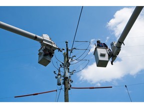 VIRGINIA BEACH, VA - AUGUST 28: Workers from Dominion Virginia Power tend to electrical lines affected by Hurricane Irene on August 28, 2011 in Virginia Beach, Virginia. The Category 1 storm, which made landfall in North Carolina early yesterday morning, has been downgraded to a tropical storm, but knocked out power to more than 3 million people and is attributed to 15 deaths as it travels up the Eastern seaboard.