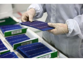 An employee performs a final inspection on solar cells on the production line at the Trina Solar Ltd. factory in Changzhou, Jiangsu Province, China, on Friday, April 24, 2015. Photographer: Tomohiro Ohsumi/Bloomberg