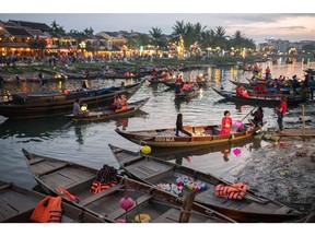 Tourists ride boats along the Thu Bon River in the old town of Hoi An, Qu?ng Nam Province, Vietnam, on Friday, April 18, 2018. With a fast-growing economy and a young population, Vietnam offers an attractive market for retailers. Its economy expanded 7.4 percent in the first quarter from the same period a year earlier, and a third of its population is aged 15 to 34. Photographer: James MacDonald/Bloomberg