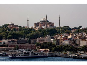 A ferry boat sits docked on the Bosporus beneath the The Hagia Sophia mosque on the city skyline in the Sultanahmet district of Istanbul, Turkey, on Tuesday, July 21, 2020. When President Recep Tayyip Erdogan reopens Istanbul's Hagia Sophia for prayers next week, it will be the crowning symbol of his mission to reassert Turkey's role as a Muslim power on the global stage. Photographer: Kerem Uzel/Bloomberg