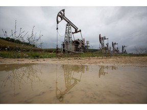 Oil pumping jacks, also known as "nodding donkeys", are reflected in a puddle as they operate in an oilfield near Almetyevsk, Russia, on Sunday, Aug. 16, 2020. Oil fell below $42 a barrel in New York at the start of a week that will see OPEC+ gather to assess its supply deal as countries struggle to contain the virus that's hurt economies and fuel demand globally.