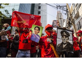 Demonstrators hold up images of Aung San Suu Kyi, left, and her father Aung San during a protest outside the Embassy of Myanmar in Bangkok, Thailand, on Monday, Feb. 1 2021. Myanmar's military detained Suu Kyi, declared a state of emergency and seized power for a year after disputing her party's landslide November election victory in a setback for the country's nascent transition to democracy. Photographer: Andre Malerba/Bloomberg