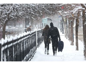 CHICAGO, ILLINOIS - FEBRUARY 02: People carry luggage down a snow-covered sidewalk on February 02, 2022 in Chicago, Illinois. A massive storm, working its way across the Midwest, is expected to dump as much as 16 inches of snow in some areas. Chicago is expected to receive between 4 and 8 inches by the time the system passes tomorrow afternoon.