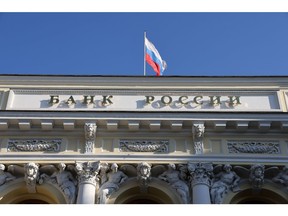 A Russian national flag above the headquarters of Bank Rossii, Russia's central bank, in Moscow, Russia, on Monday, Feb. 28, 2022. The Bank of Russia acted quickly to shield the nation's $1.5 trillion economy from sweeping sanctions that hit key banks, pushed the ruble to a record low and left President Vladimir Putin unable to access much of his war chest of more than $640 billion.