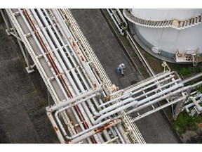 A worker walks under pipelines at Jera Co.'s liquefied natural gas (LNG) fired power plant inside the company's Anegasaki Thurmal Power Station in Ichihara, Chiba Prefecture, Japan, on Wednesday, June 22, 2022. Jera, a joint venture between Tokyo Electric Power Co. (Tepco) and Chubu Electric Power Co., won the bid in a public auction to supply additional power during this summer. Homes and businesses are being asked to conserve electricity to help avoid blackouts during a squeeze on global energy supplies. Photographer: Akio Kon/Bloomberg