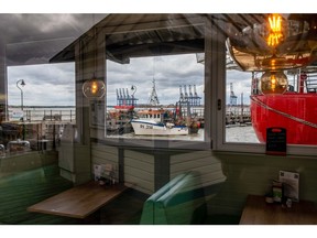 Idle ship-to-shore cranes, seen through the windows of an empty restaurant, on the dockside during the first-day of the second strike action by Unite union members and dockworkers at the Port of Felixstowe, UK, on Tuesday, Sept. 27, 2022. Dock workers at Felixstowe, Britain's largest container port, rejected a pay deal imposed by management, that paved the way for this new round of industrial action and disruption to vital trade flows.