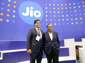 Mukesh Ambani, chairman of Reliance Industries Ltd., right, with his son Akash Ambani, chairman of Reliance Jio Infocomm Ltd., visit a company's stall at India Mobile Congress 2022 in New Delhi, India, on Saturday, Oct. 1, 2022. Narendra Modi, India's prime minister, announced the launch of 5G services in India during the event on Oct. 1.