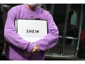 A customer holds a Shein bag outside the Shein Tokyo showroom in Tokyo, Japan, on Sunday, Nov. 13, 2022. Fast fashion retailer Shein opened its first permanent store in the world in the Harajuku district of Tokyo on Sunday, Nov. 13. Photographer: Noriko Hayashi/Bloomberg