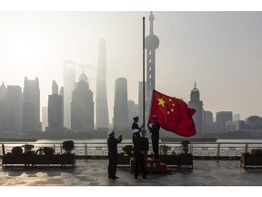 Bloomberg Best of the Year 2022: China Customs officers raise a Chinese flag during a rehearsal for a flag-raising ceremony along the Bund in front of the Lujiazui Financial District at sunrise in Shanghai, China, on Tuesday, Jan. 4, 2022. Photographer: Qilai Shen/Bloomberg